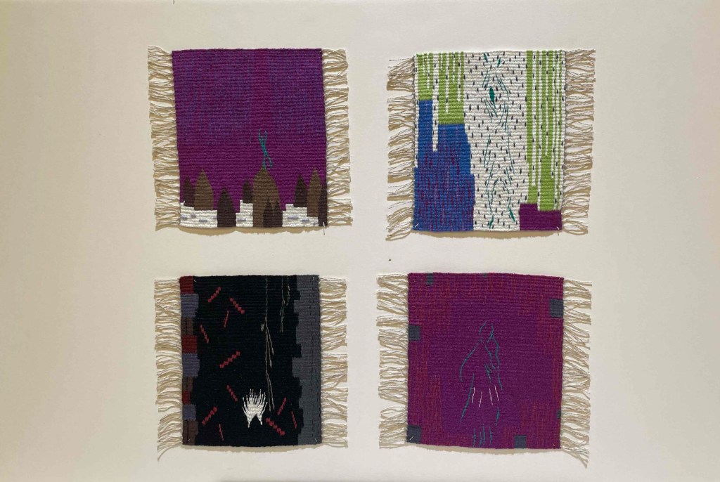 Photo of four small tapestries mounted in shades of purple, blue, green, gray, pink, and black