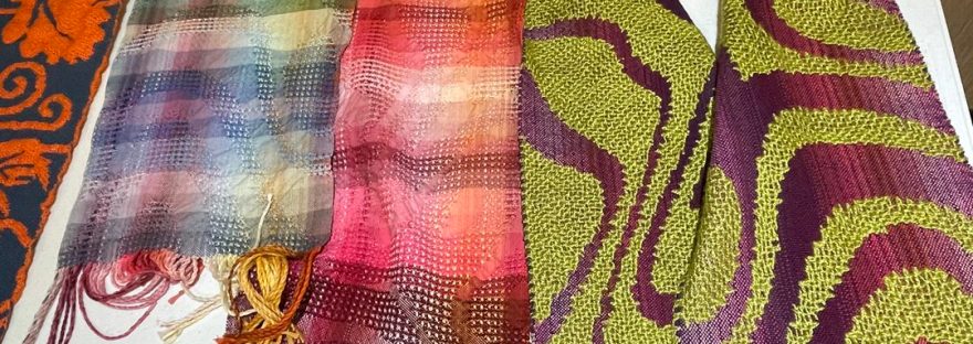 Small samples of fabric woven with different structures displayed on a table.