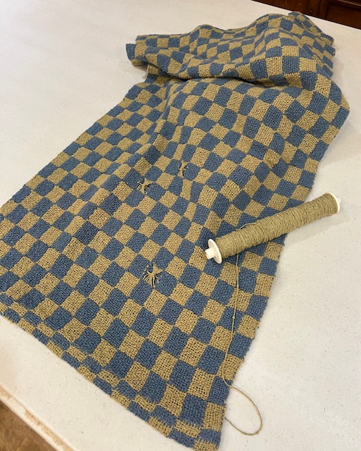 Checkered, textured towel woven in shades of green and blue, with a few accent blocks woven in Leno lace.