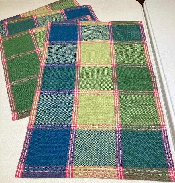 Three hemmed towels woven in blocks of teal, light green, and darker green with red and white dividing accents and edges.