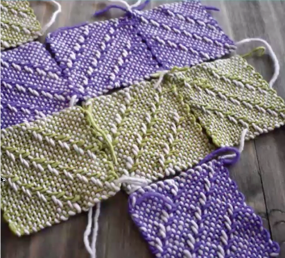 Several pin loom-woven squares in shades of purple and white and green and white arranged on a table.