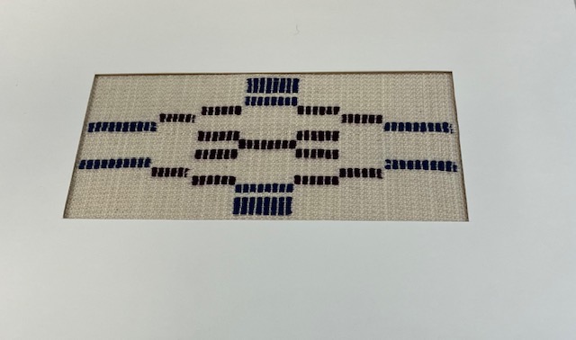 Abstract tapestry-like weaving in shades of cream, dark blue, and dark red. Cream is the dominant color.