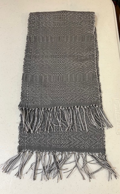 Fringed scarf woven in dark dray and white.