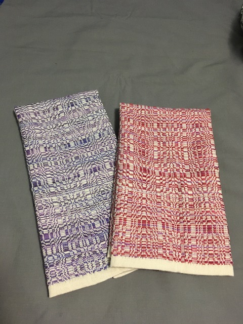 Two fingertip towels - Three woven objects - one is woven in shades of blue and cream, and the other towel woven in shades of dark red and cream.