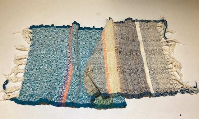 Fringed fabric with the left half being patterned ub shades if aqua, cream, purple, and orange, and the right half woven in shades of aqua, cream, yellow, orange, light blue, black, brown, and cream.