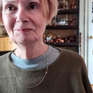 A woman wearing a dark green woven shirt. 