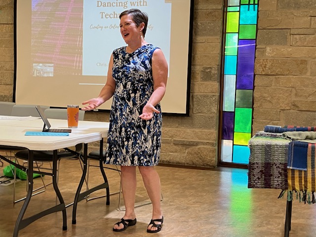 Woman standing in front of a projection screen giving a talk