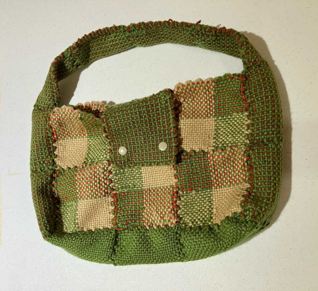 Handwoven purse in shades of green, tan, and rust