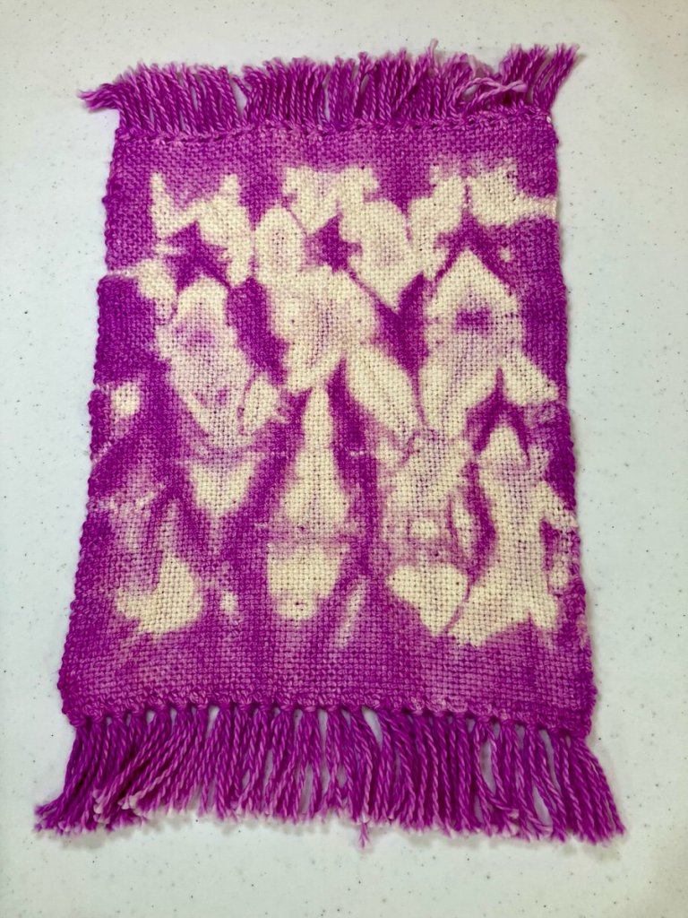 Small violet plain woven strip with white resist dye spots.