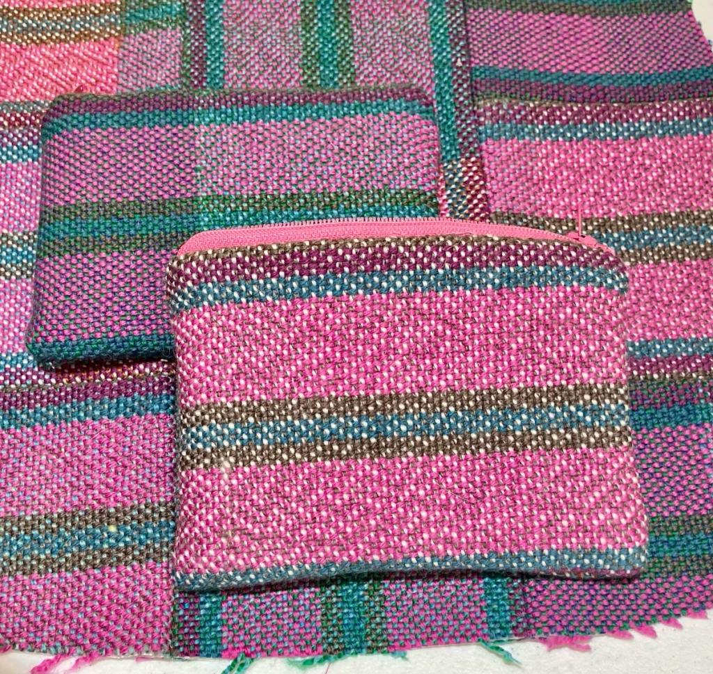 Two striped zippered pouches in purples, blues, and grays.