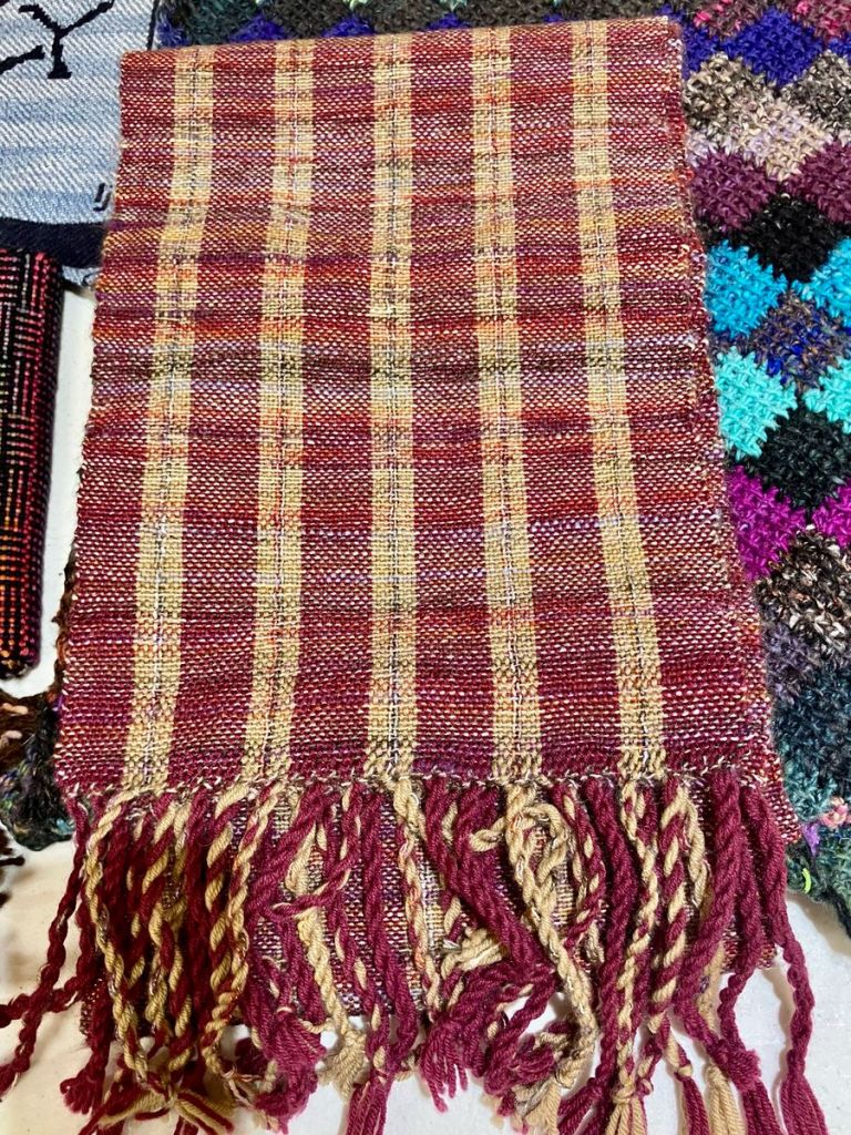 Striped scarf with beige and burgundy bands.