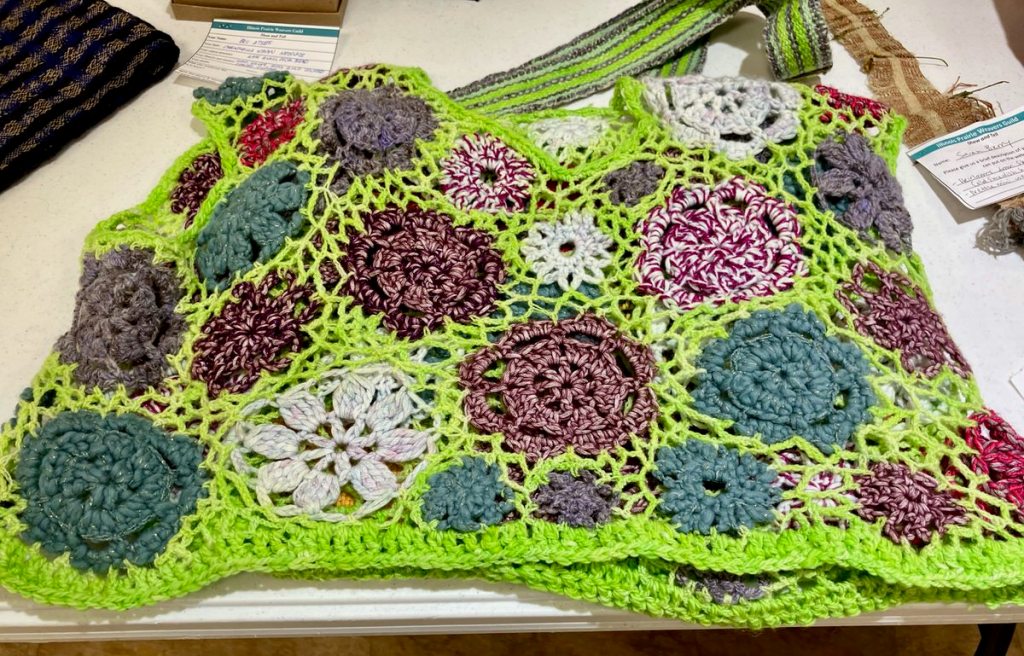 Crochet top that matches Pia's bag. Flowers of various colors joined by a fluorescent green netted crochet stitch.