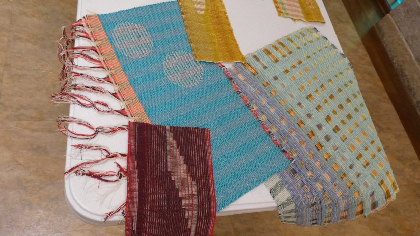 Several colorful woven samples featuring intricate shapes