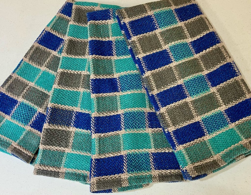 Four towels featuring dark blue, light blue, dark gray rectangles enclosed by a light gray border.