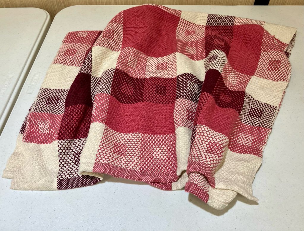 Dark and light squares in various shades of red and pink with some solid white squares.