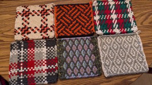 Six square patterned potholders in various colors, lying on a table
