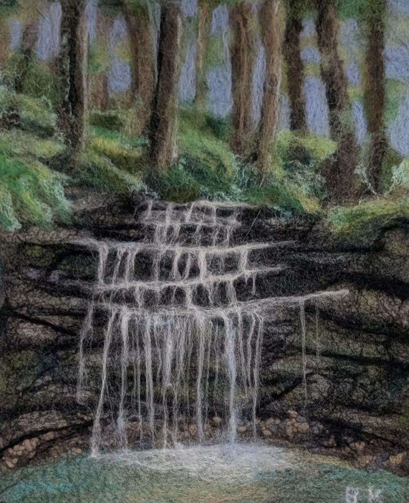 Felted forest waterfall scene.