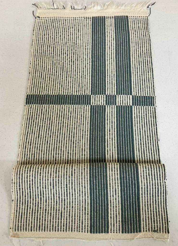 Chris M. - Runner with two vertical and on horizontal thin dark blue stripes.