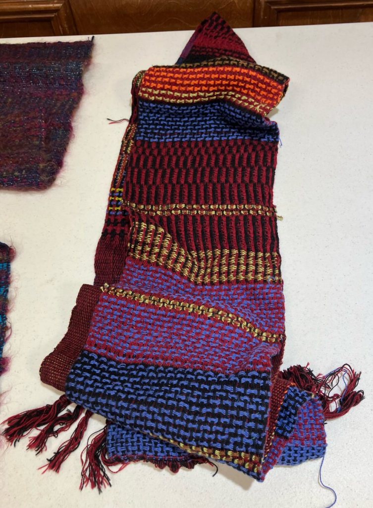 Strip of double huck woven fabric done in warm colors.