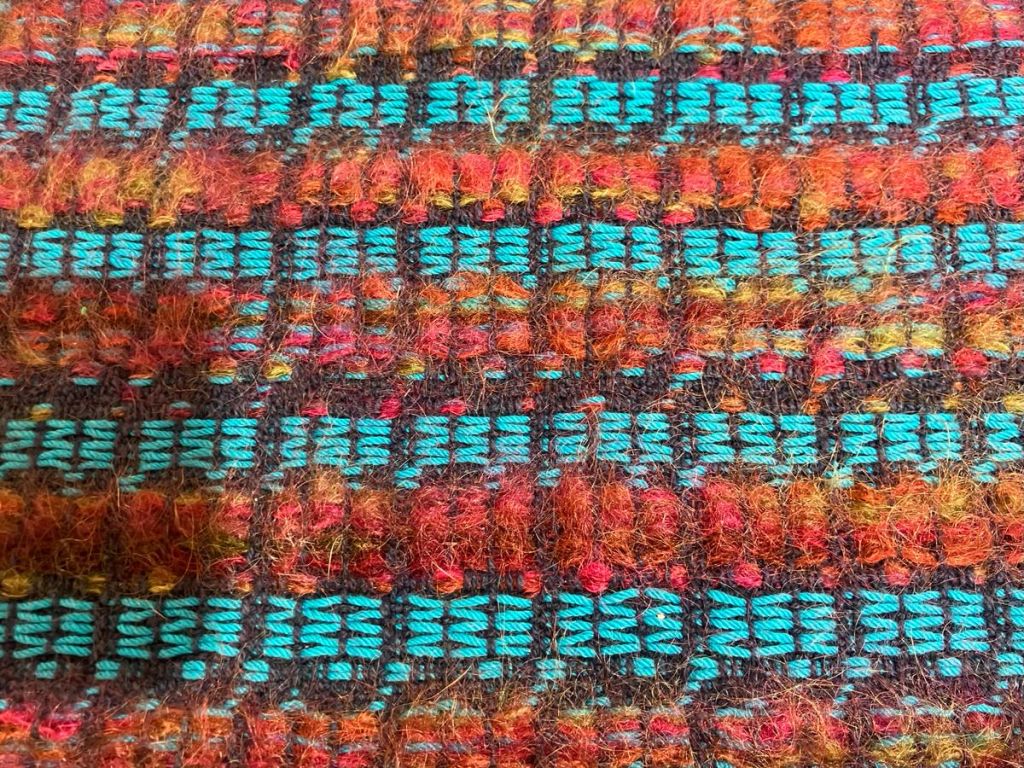 Close-up of an overshot project in blue and warm colors.