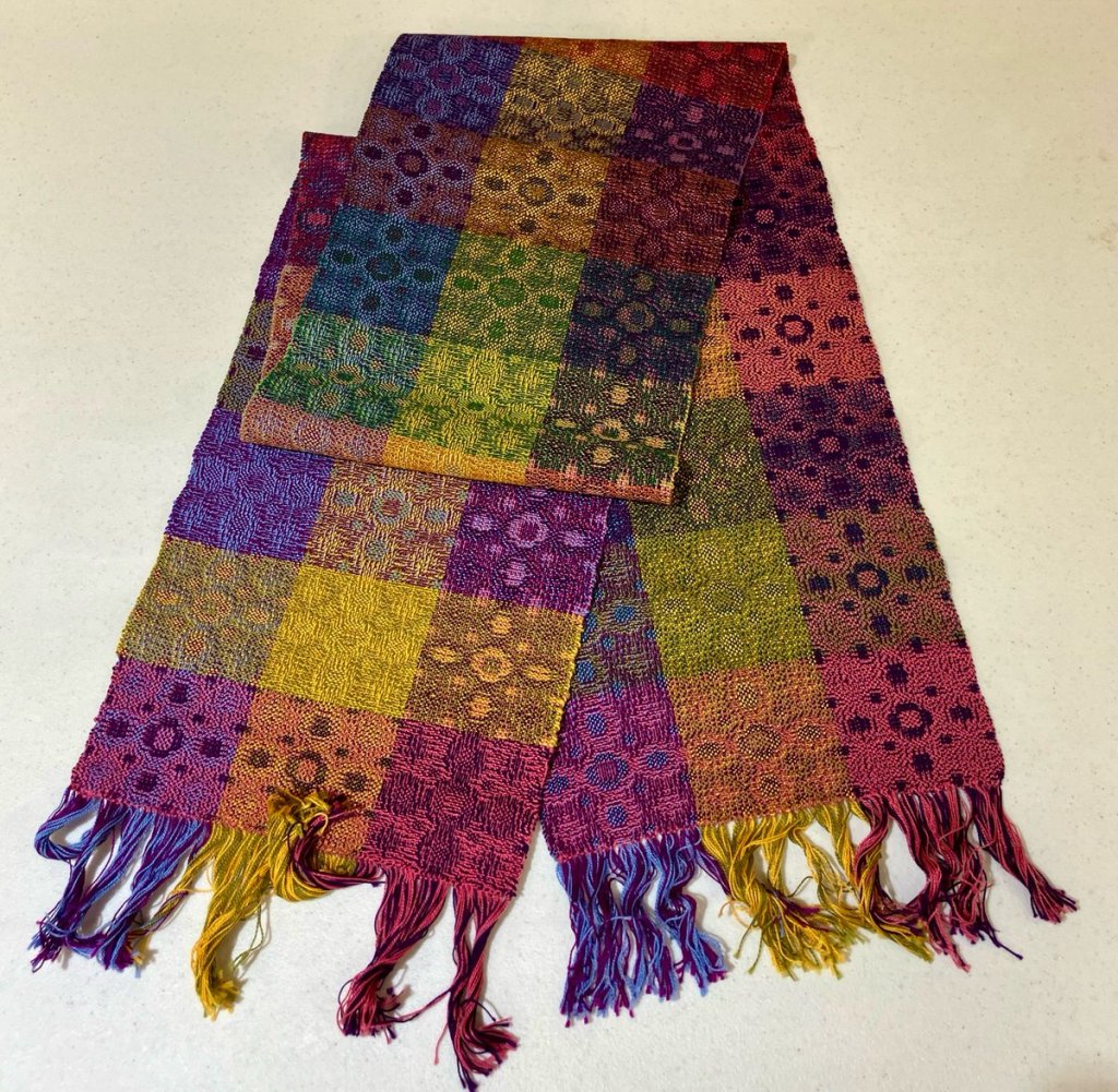 David L. - Scarf, floral motif using blue, yellow and dark pink weft threads.