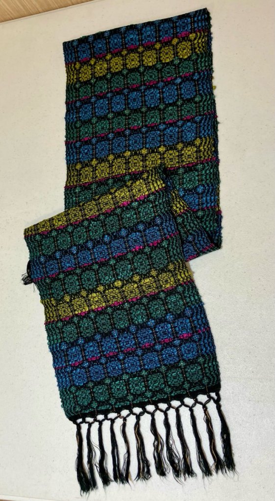 Jan M. - Overshot scarf using bands of blue, green, and yellow as the weft.