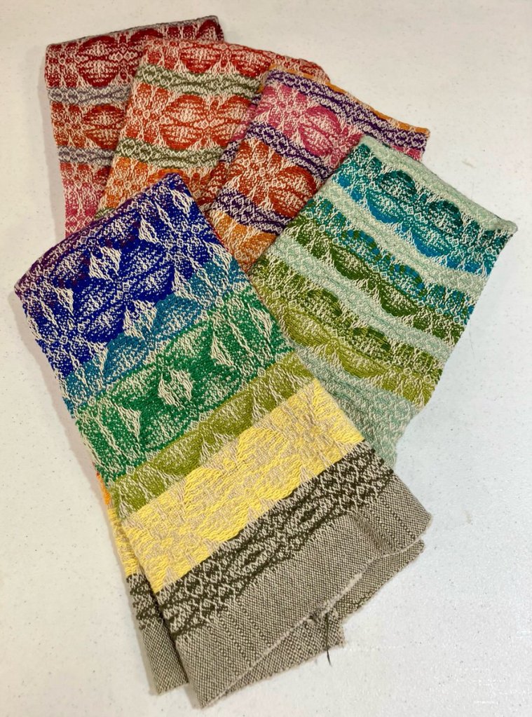 Phyllis S. - Five towels, using rows of abstract moth shapes done in a variety of colors.