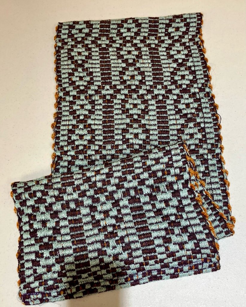 Pia T. - Chain and linear strips of rep weave done in light green and dark brown.
